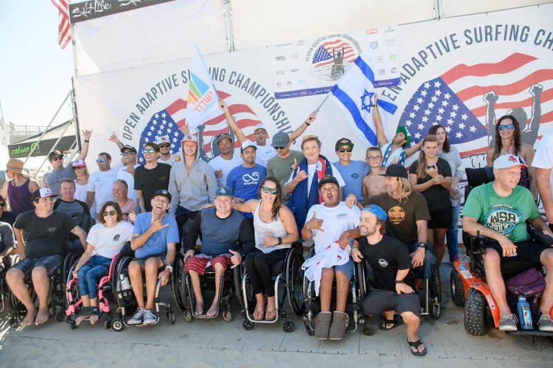 Image of adaptive surfers posing in front of the US Open banner during awards